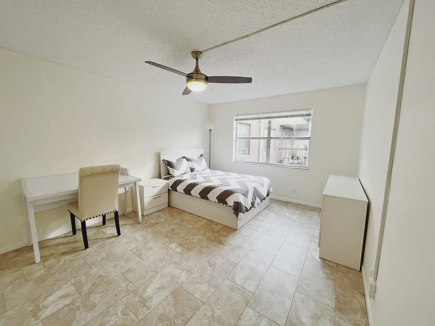 A living room with beige tile flooring, a sectional sofa, and a large wall clock — 7080 Nova Drive # 307b, Davie FL 33317, DAVIE, FL