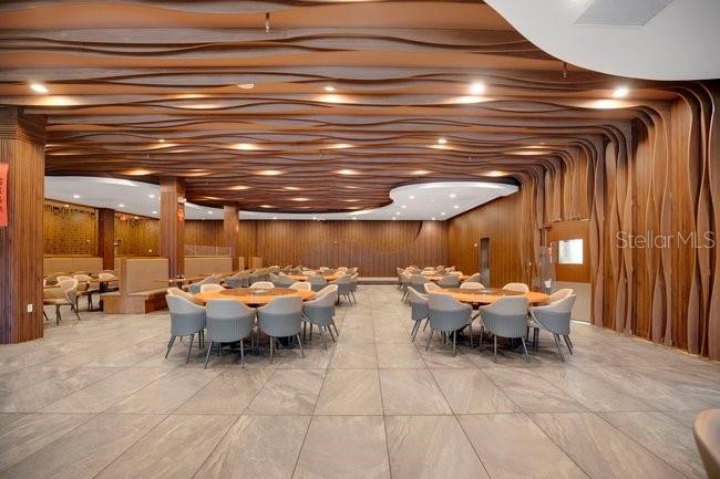 A dining room features a wavy wood-slat ceiling, tile flooring, and multiple round tables — 1101 E COLONIAL DRIVE, ORLANDO, FL