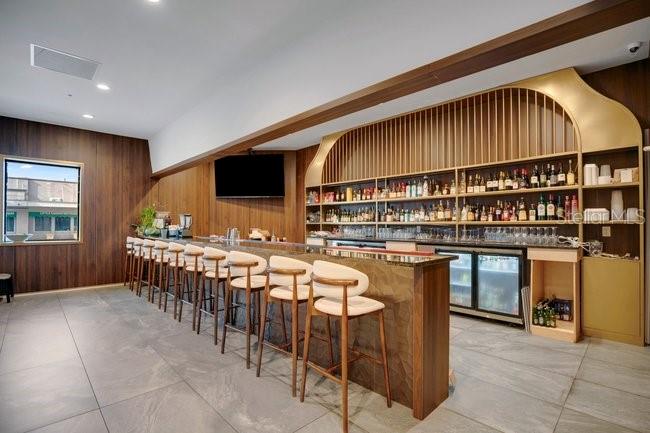 A modern bar area features wooden cabinetry, a stone-topped counter, and several high-backed stools — 1101 E COLONIAL DRIVE, ORLANDO, FL