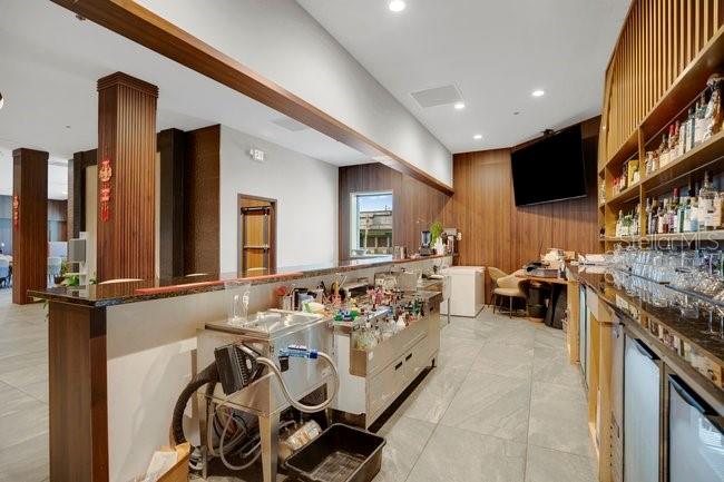 A commercial bar area features wood-paneled walls, a stainless steel prep station, and tiled flooring — 1101 E COLONIAL DRIVE, ORLANDO, FL