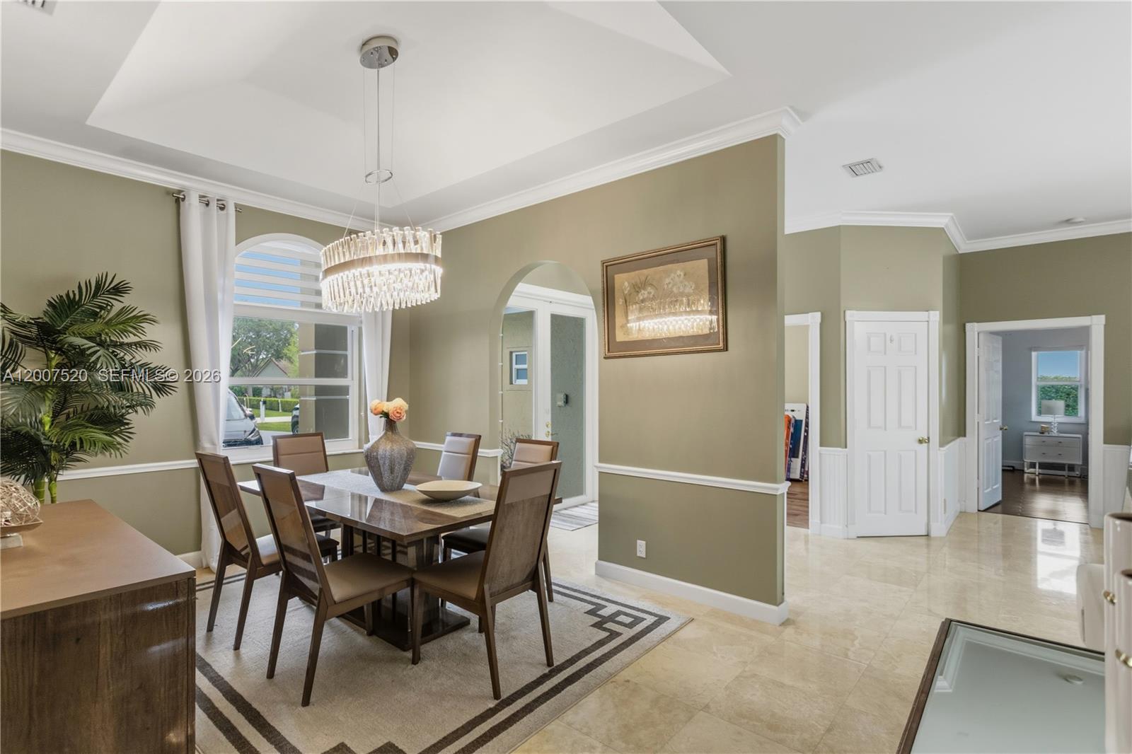 A dining room features a crystal chandelier, beige walls with wainscoting, and tile flooring — 12343 NW 19th St, Plantation FL 33323, PLANTATION, FL