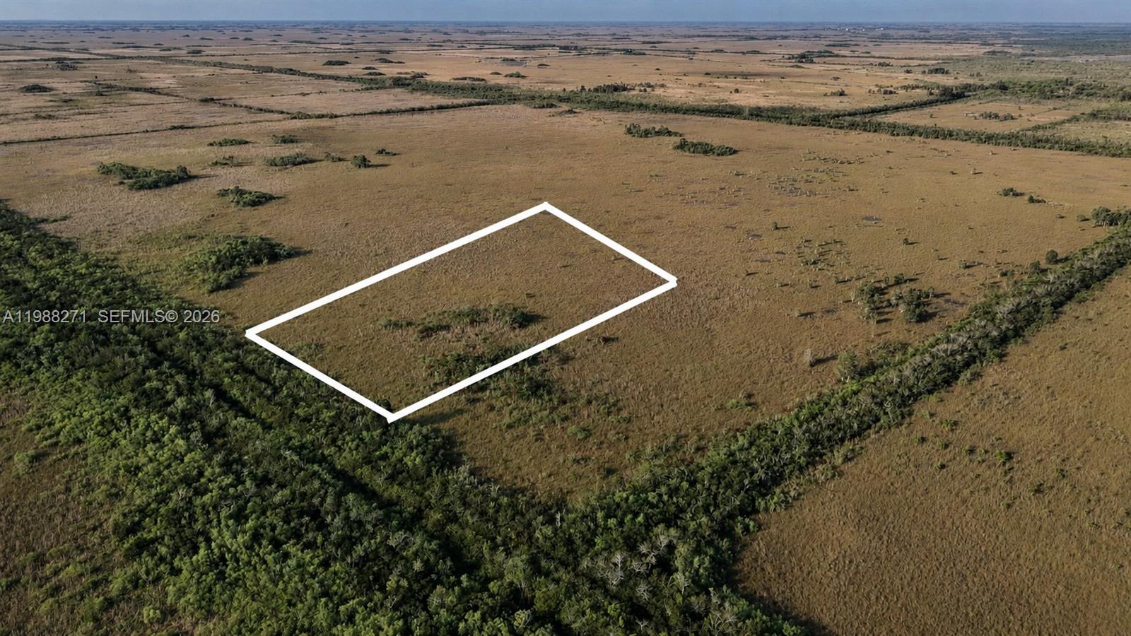 An aerial view shows a rectangular plot of land outlined in white amidst open fields — 0 Unknown Road, Unincorporated Dade County FL 33034, UNINCORPORATED DADE COUNTY, FL