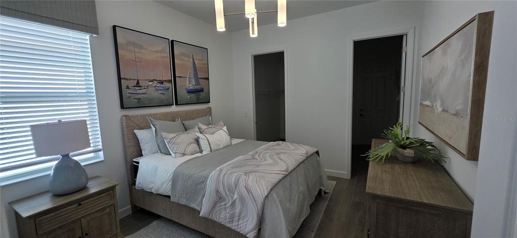 A bedroom features a bed, two framed sailboat pictures, a dresser, and a light fixture — 8006 LAKES EDGE LANE, PORT CHARLOTTE, FL