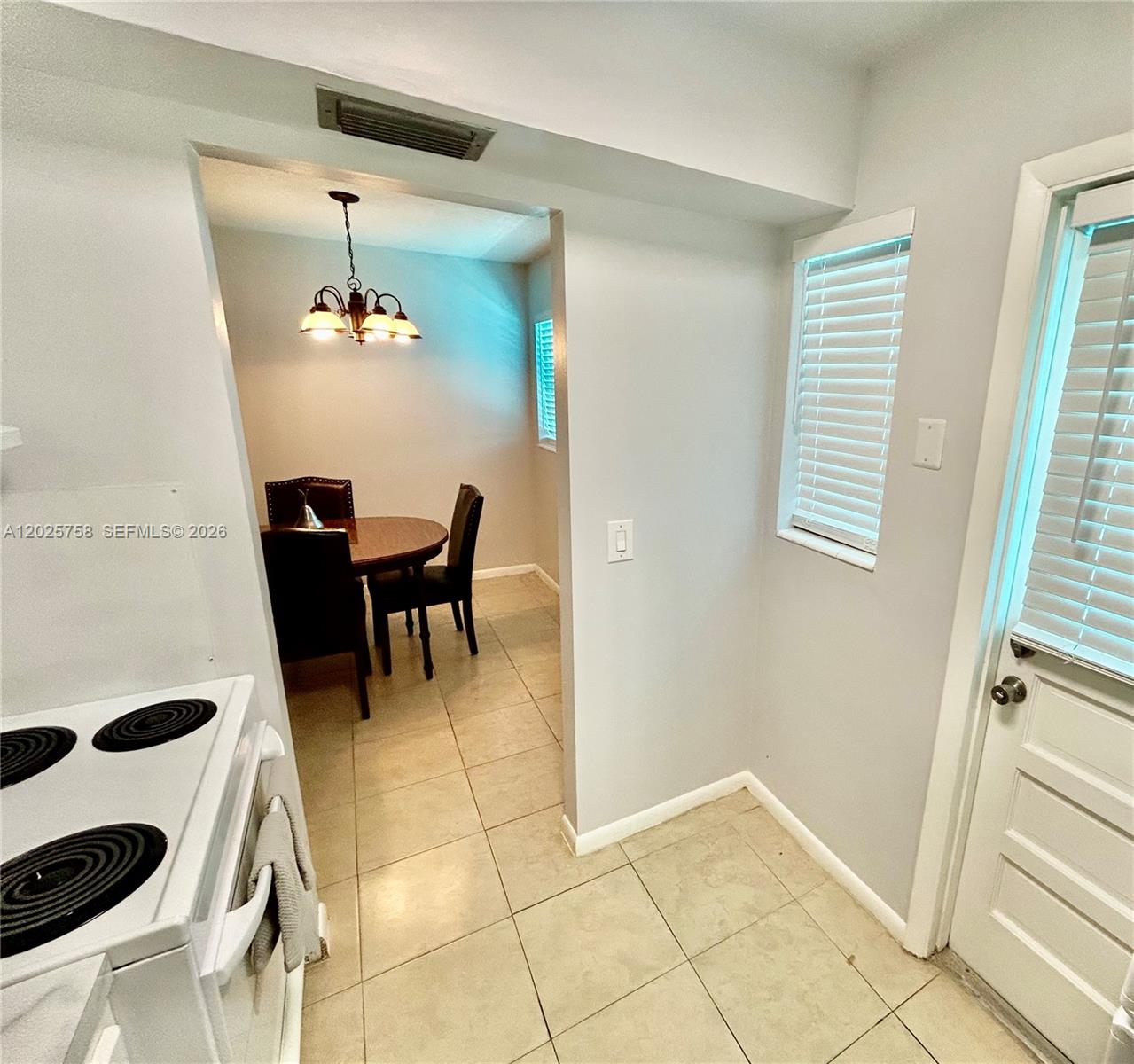 A kitchen with a white stove leads into a dining area with a round table — 2213 NE 1st Ct # 203, Boynton Beach FL 33435, BOYNTON BEACH, FL
