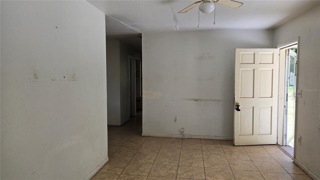 An interior view of a room with tile flooring, white walls, and an open doorway — 6404 SW 9TH AVENUE, OCALA, FL