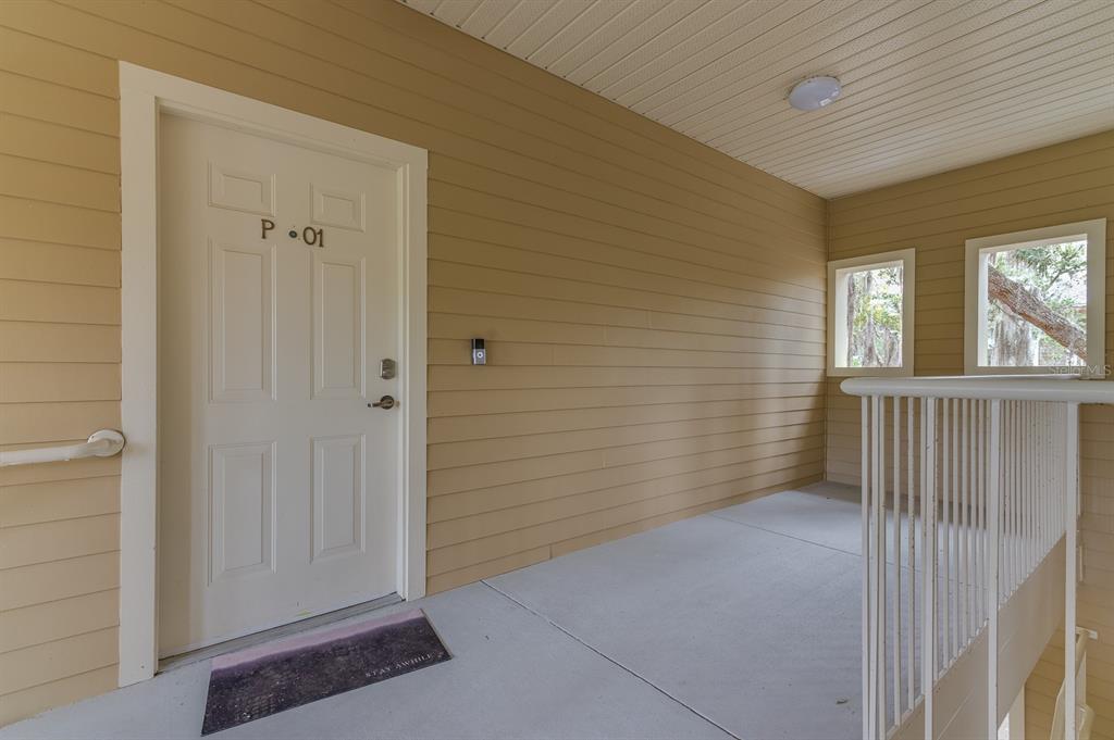 An exterior view of a building entrance with a white door labeled P-01 — 4850 SW 91ST TERRACE UNIT 301, GAINESVILLE, FL