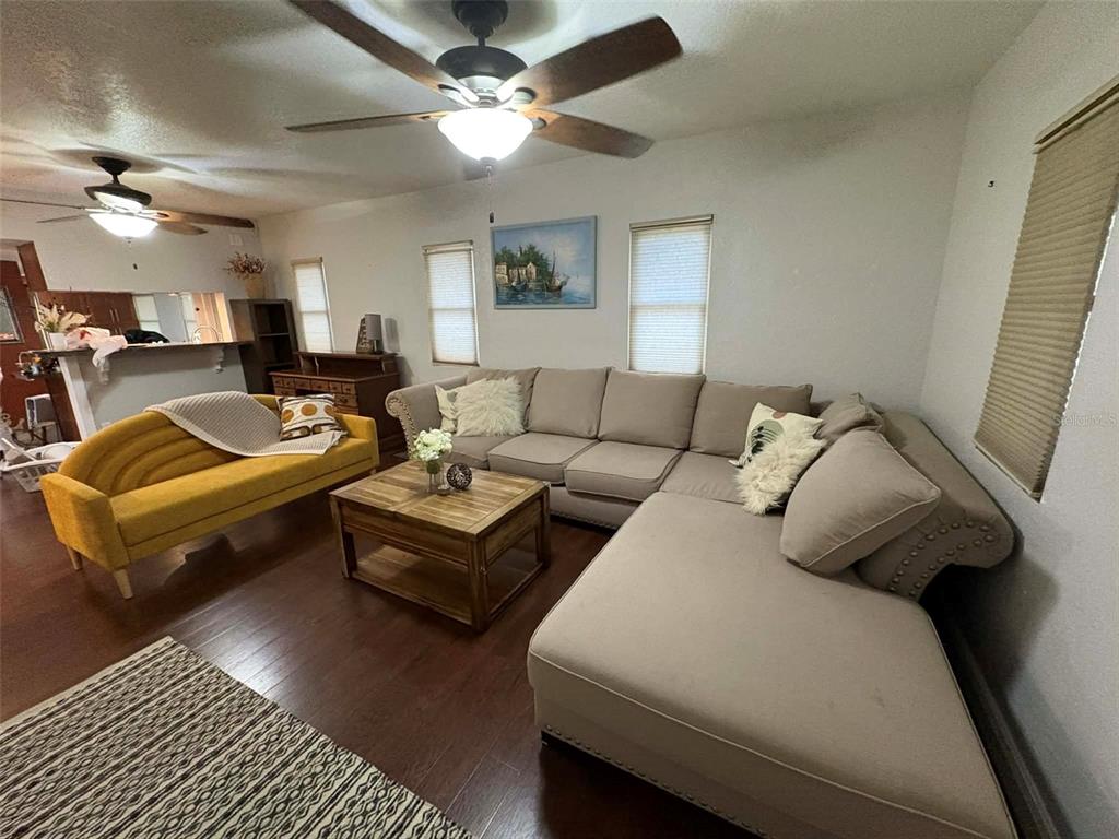 A living room features a large sectional sofa, a yellow couch, and a wooden coffee table — 1040 S OHIO AVE, LAKELAND, FL