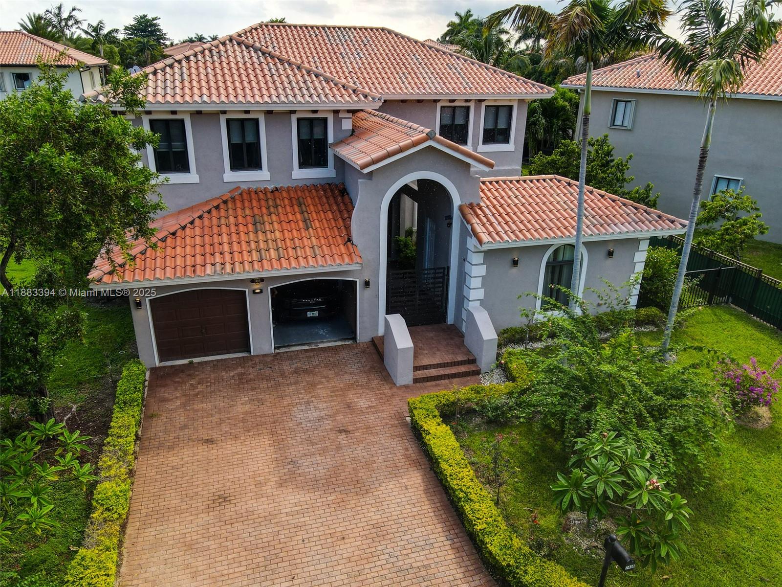 A two-story house with a terracotta tile roof, brick driveway, and a two-car garage — 7408 SW 189th St, Cutler Bay FL 33157, CUTLER BAY, FL
