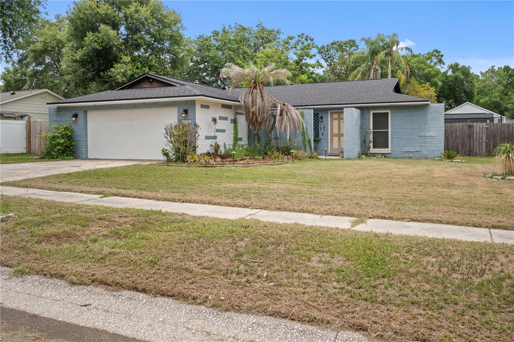 A single-story house with a blue brick exterior, a two-car garage, and a front lawn — 2015 RONALD CIRCLE, SEFFNER, FL