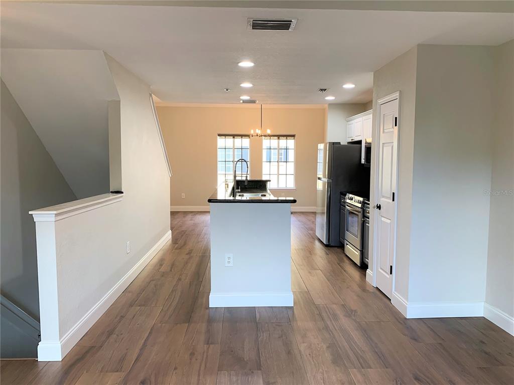 A kitchen with a central island, stainless steel appliances, and wood-look flooring — 5208 HAMPTON BEACH PLACE UNIT 5208, TAMPA, FL