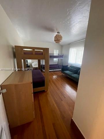 A bedroom with hardwood floors, a wooden bunk bed, and a dark green sofa — 2811 Indian Creek Dr, Miami Beach FL 33140, MIAMI BEACH, FL