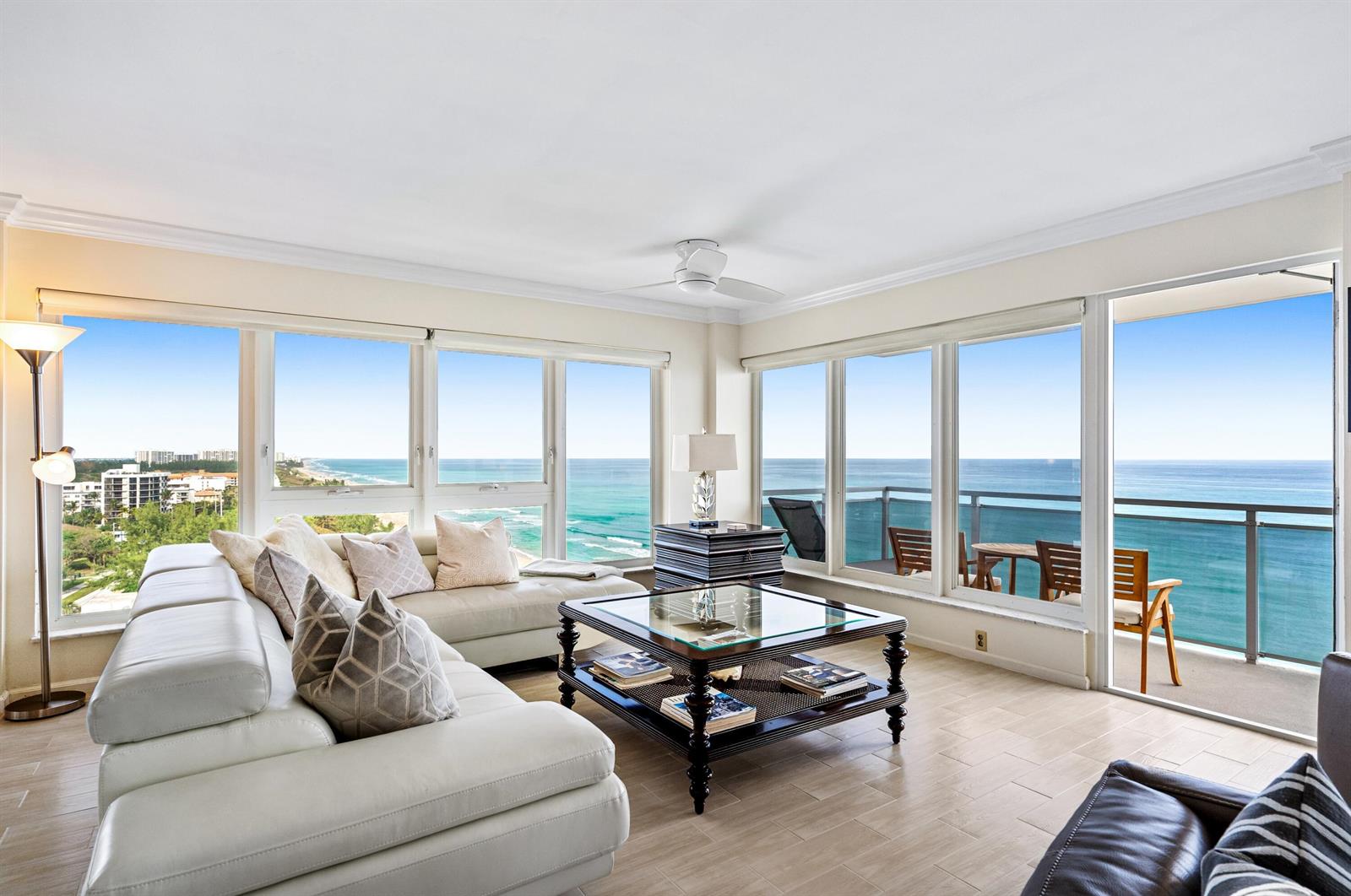 A living room with a white sectional sofa, glass coffee table, and panoramic ocean views — 2066 N Ocean Boulevard, Boca Raton FL 33431, BOCA RATON, FL