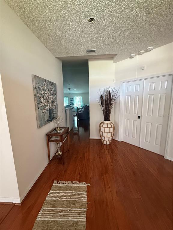 A foyer with hardwood floors, a console table, a decorative vase, and white double doors — 4 BALLARD LANE, PALM COAST, FL