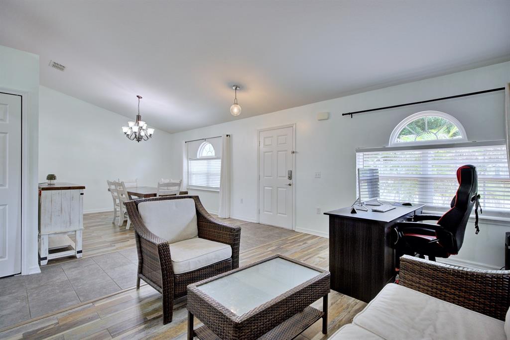 A multi-purpose room features wood-look flooring, a dining area, and a home office setup — 4710 TARREGA STREET, SEBRING, FL