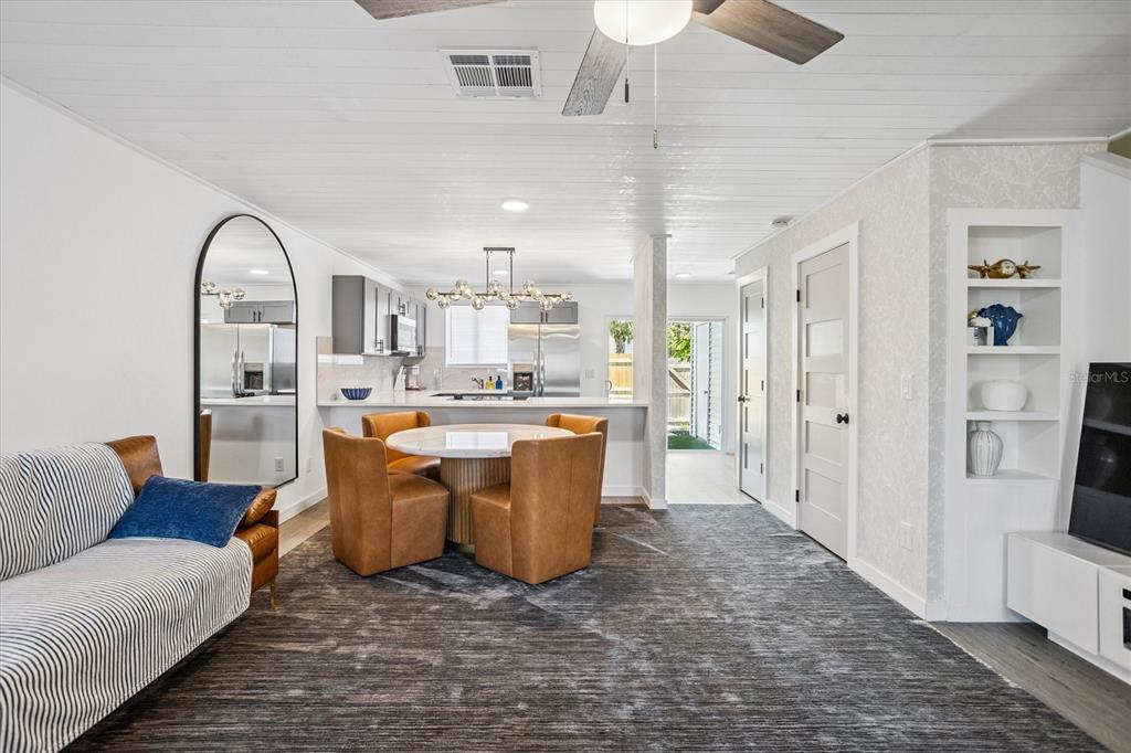 A living room and dining area feature a large area rug, leather chairs, and kitchen — 4712 STONEPOINTE PLACE, TAMPA, FL