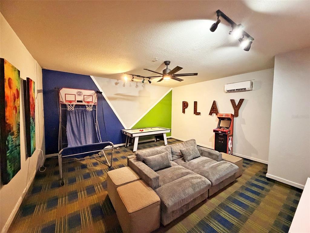 A game room features a sectional sofa, air hockey table, arcade cabinet, and basketball hoop — 7805 BEECHFIELD STREET, KISSIMMEE, FL