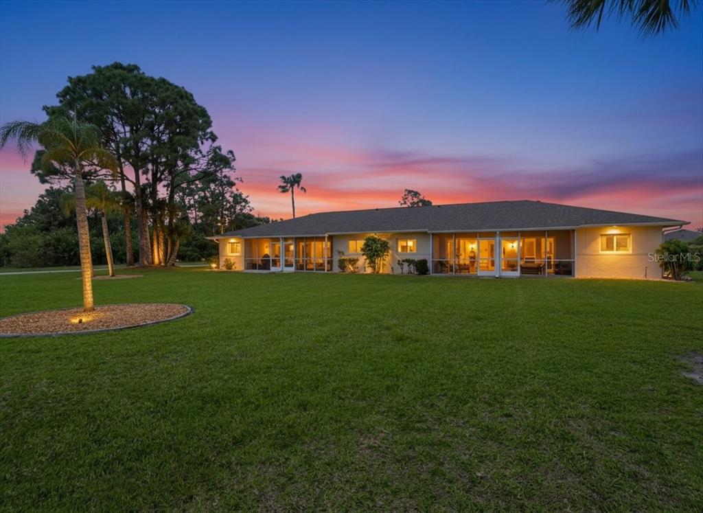 A single-story multi-unit building with a parking lot in the foreground at sunset — 12538 SW KINGSWAY CIRCLE UNIT 1503, LAKE SUZY, FL