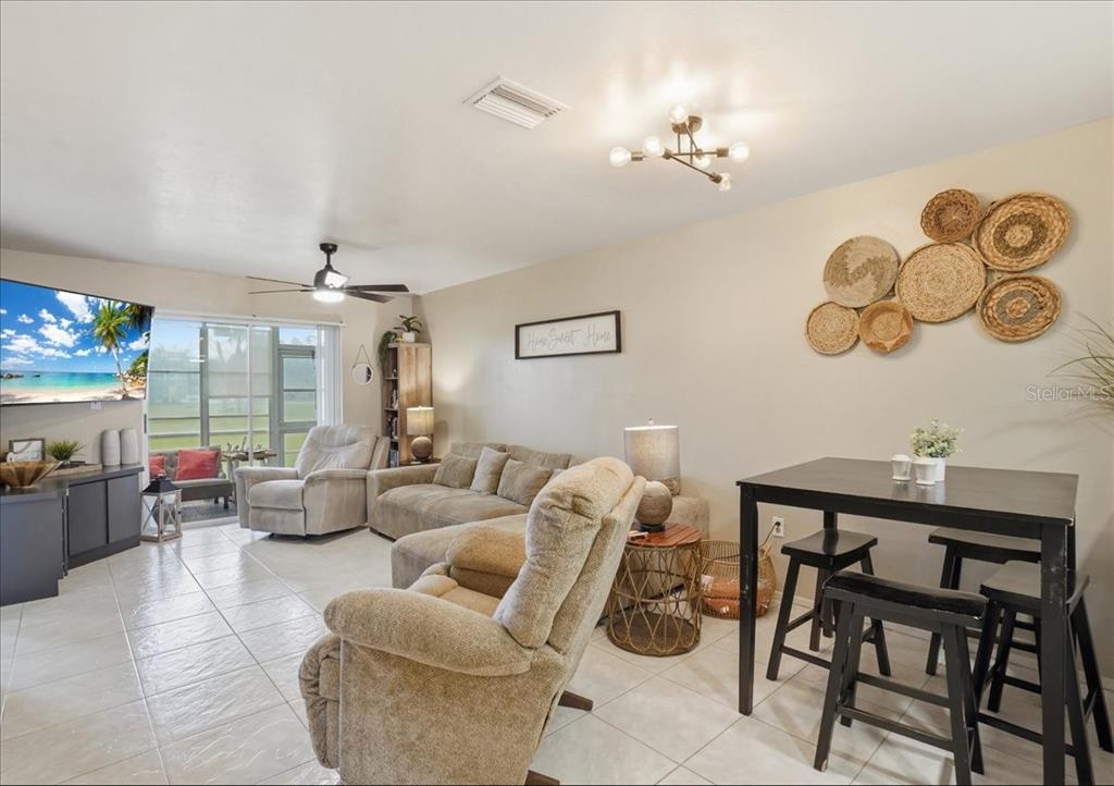 The exterior of a single-story house with a screened-in porch at sunset — 12538 SW KINGSWAY CIRCLE UNIT 1503, LAKE SUZY, FL