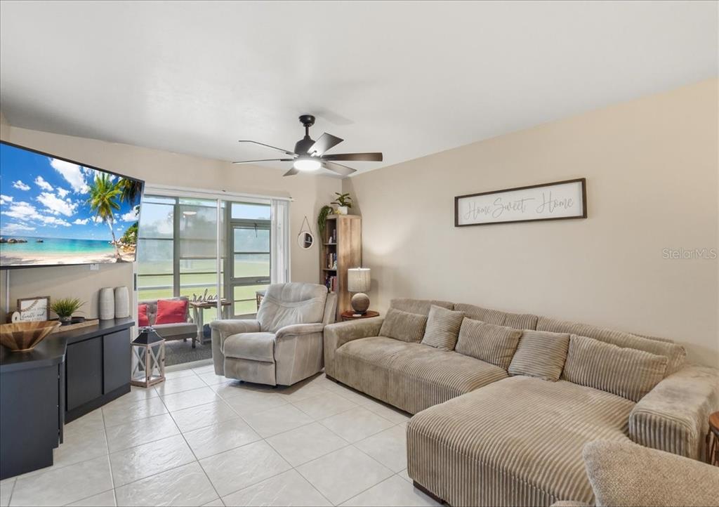 This living and dining area features tile flooring, a ceiling fan, and wall-mounted basket decor — 12538 SW KINGSWAY CIRCLE UNIT 1503, LAKE SUZY, FL
