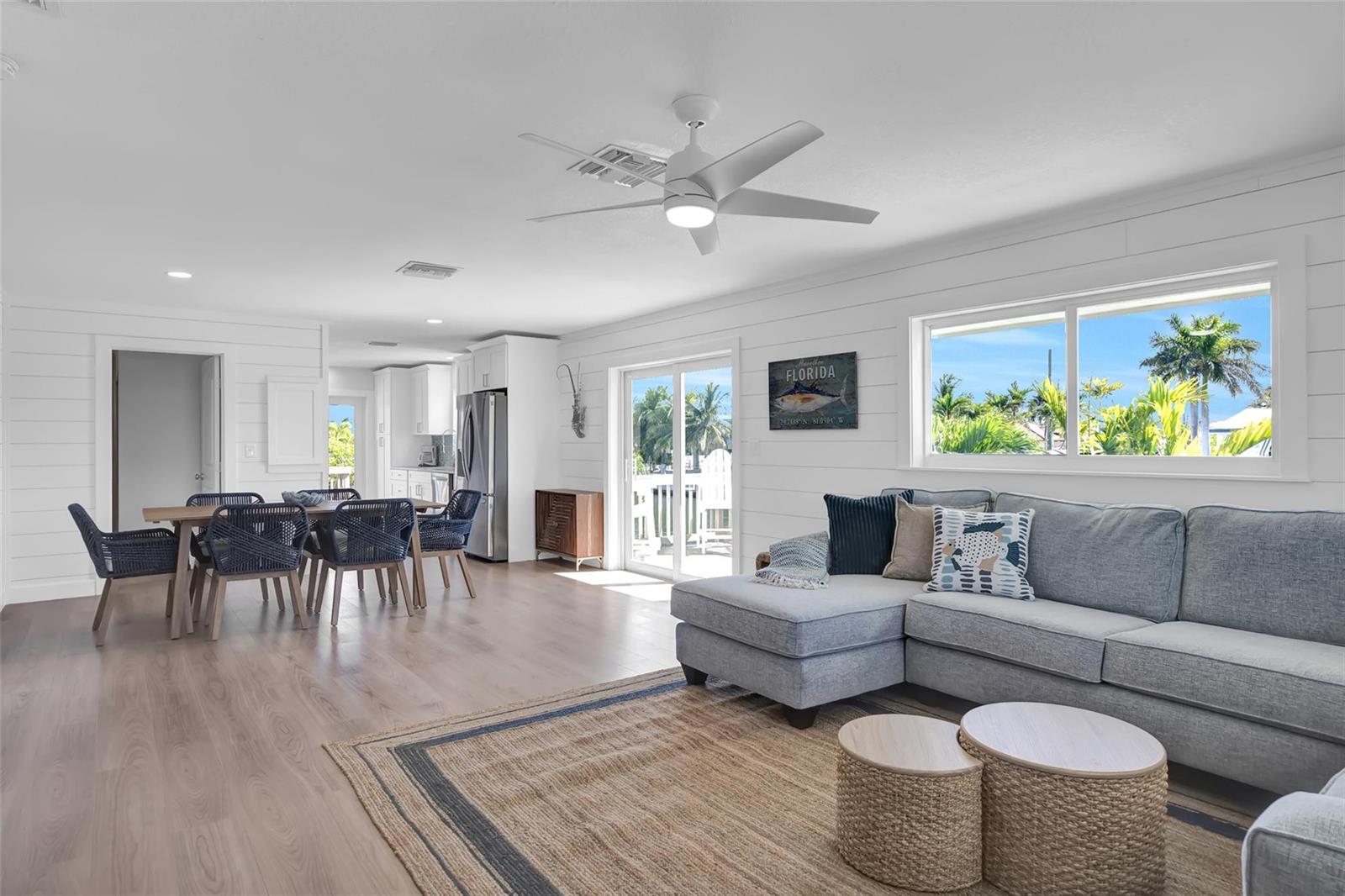 A bright living and dining area features white shiplap walls, light wood flooring, and furniture — 10999 Ave 3rd Avenue, Marathon FL 33050, MARATHON, FL