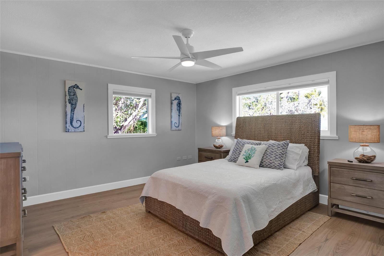 A bedroom features gray paneled walls, a woven bed frame, and a ceiling fan — 10999 Ave 3rd Avenue, Marathon FL 33050, MARATHON, FL
