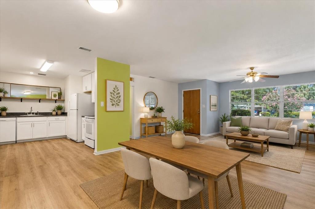 An open-concept living and dining area features light wood floors and a lime green wall — 1302 NE 14TH TERRACE, GAINESVILLE, FL