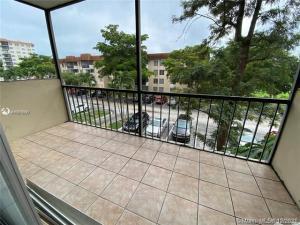A screened-in balcony with light-colored tile flooring overlooks a parking lot and apartment buildings — 4166 Inverrary Drive # 303, Lauderhill FL 33319, LAUDERHILL, FL