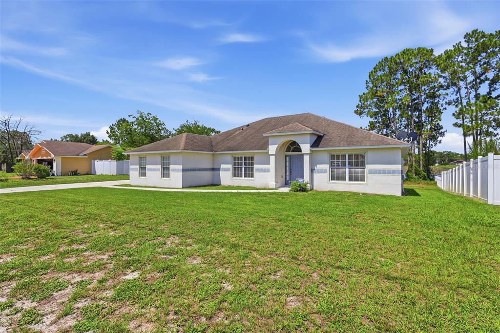 A single-story house with a white stucco exterior and a brown shingled roof — 516 GLEN HAVEN DRIVE, DELTONA, FL