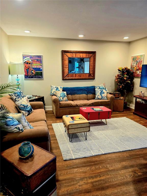 A living room features brown sofas, a large mirror, and vintage suitcase-style coffee tables — 13125 WILCOX ROAD UNIT 5104, LARGO, FL