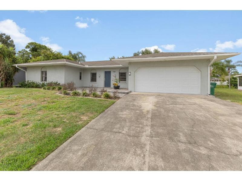 A single-story house with a light-colored stucco exterior, a two-car garage, and a concrete driveway — 758 Beard Avenue, Sebastian FL 32958, SEBASTIAN, FL