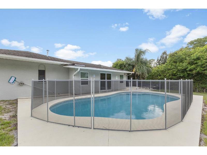 A backyard swimming pool is enclosed by a safety fence behind a single-story house — 758 Beard Avenue, Sebastian FL 32958, SEBASTIAN, FL