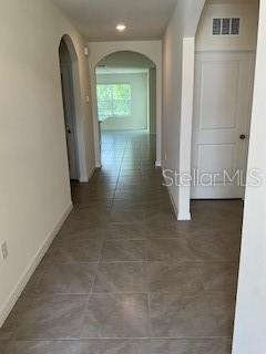 A tiled hallway leads toward an arched doorway opening into a bright living area — 35 HICKORY COURSE TRAIL, OCALA, FL