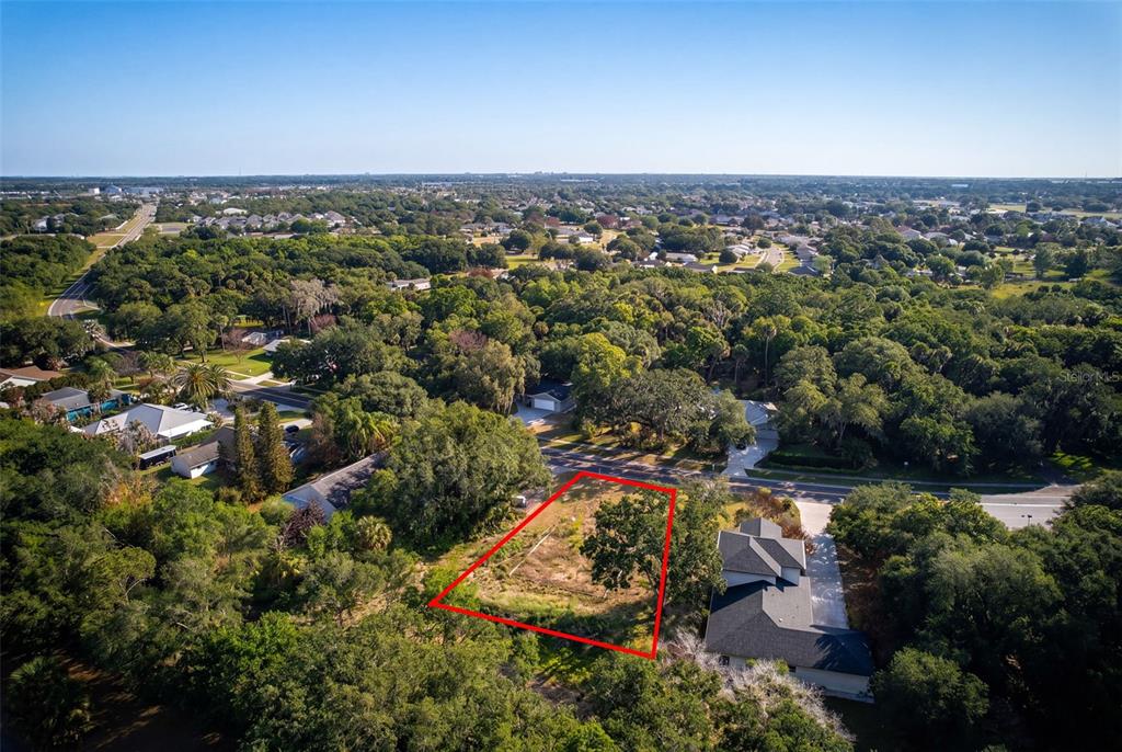 An aerial view shows a vacant, rectangular lot outlined in red next to a house — 750 RIVIERA DRIVE NE, PALM BAY, FL
