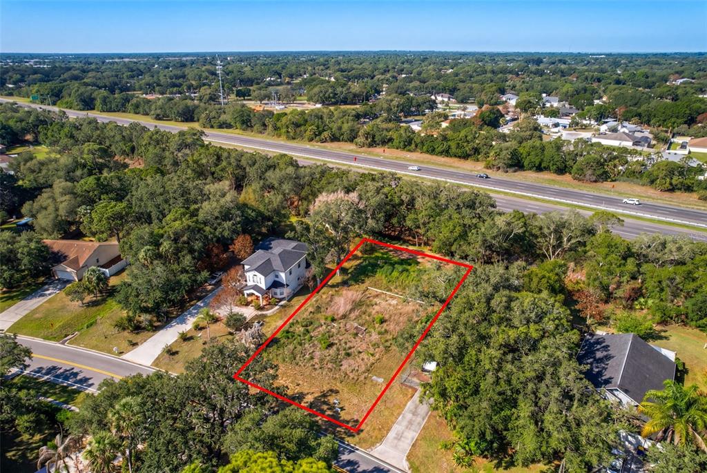 An aerial view shows a vacant rectangular lot outlined in red next to a house — 750 RIVIERA DRIVE NE, PALM BAY, FL