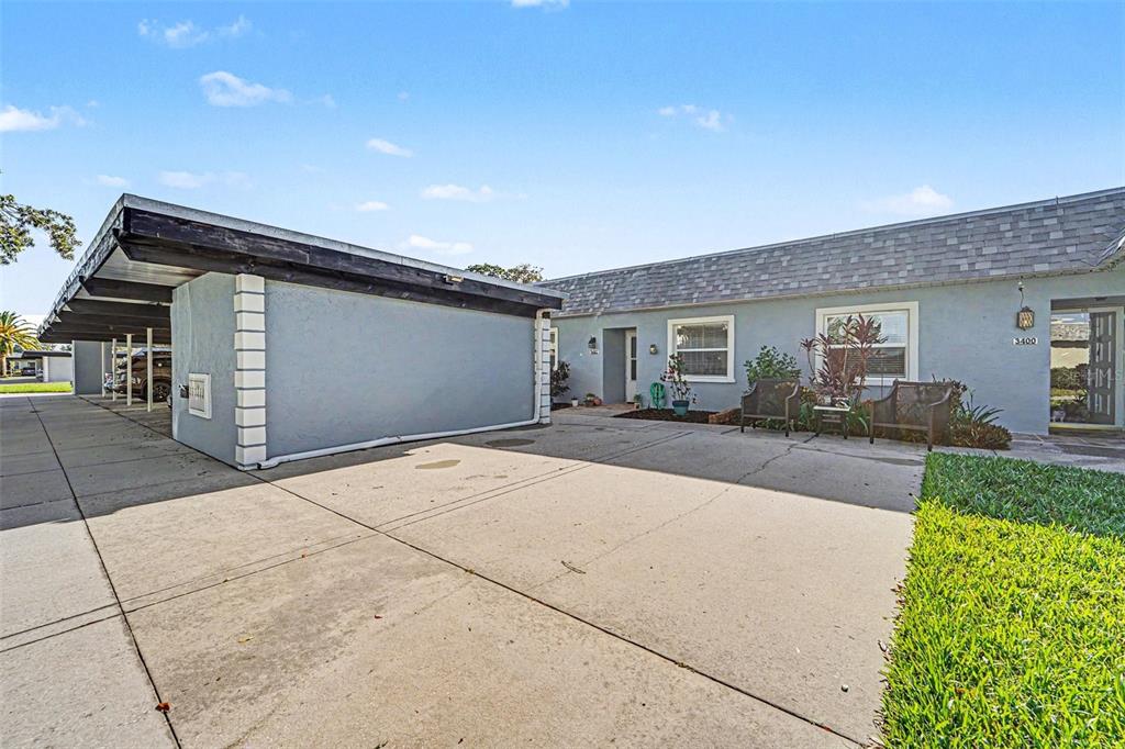 A single-story building with a carport and a concrete driveway under a blue sky — 3402 TEESIDE DRIVE, NEW PORT RICHEY, FL