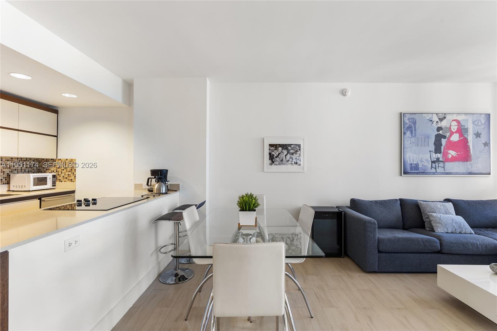 A modern kitchen features stainless steel appliances, white cabinetry, and a quartz-topped island — 2155 Washington Ct # 401, Miami Beach FL 33139, MIAMI BEACH, FL