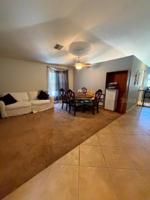 A living and dining area features a white sofa, a wooden table, and tile flooring — 409 SEA HOLLY DRIVE, BROOKSVILLE, FL