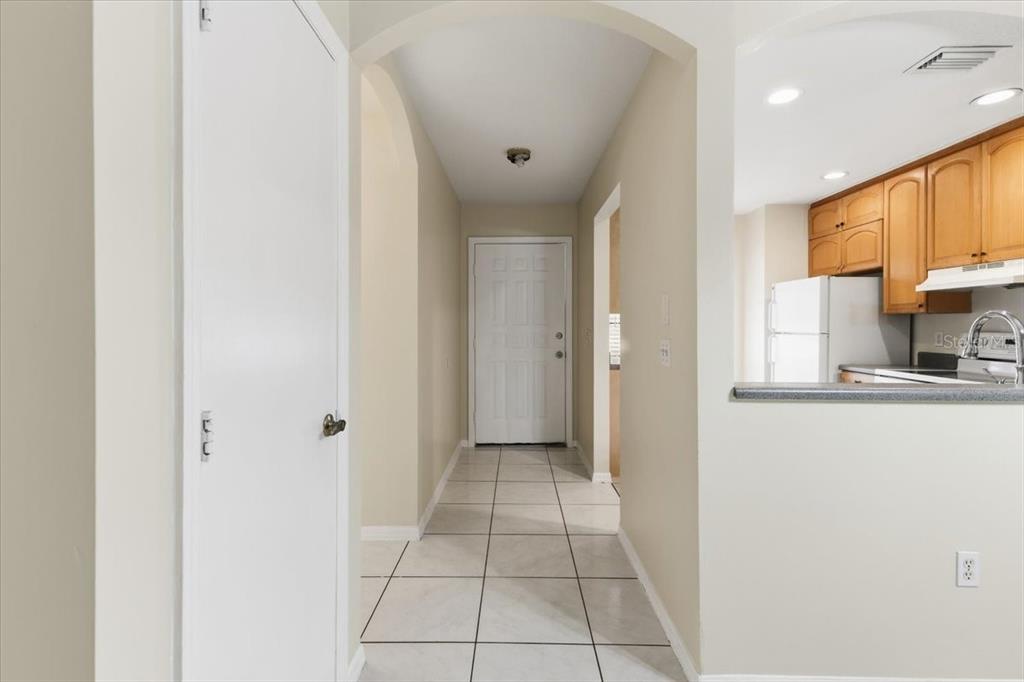 A tiled entryway leads to a white front door with a kitchen visible to the right — 10507 PENDLETON AVENUE UNIT B, ENGLEWOOD, FL