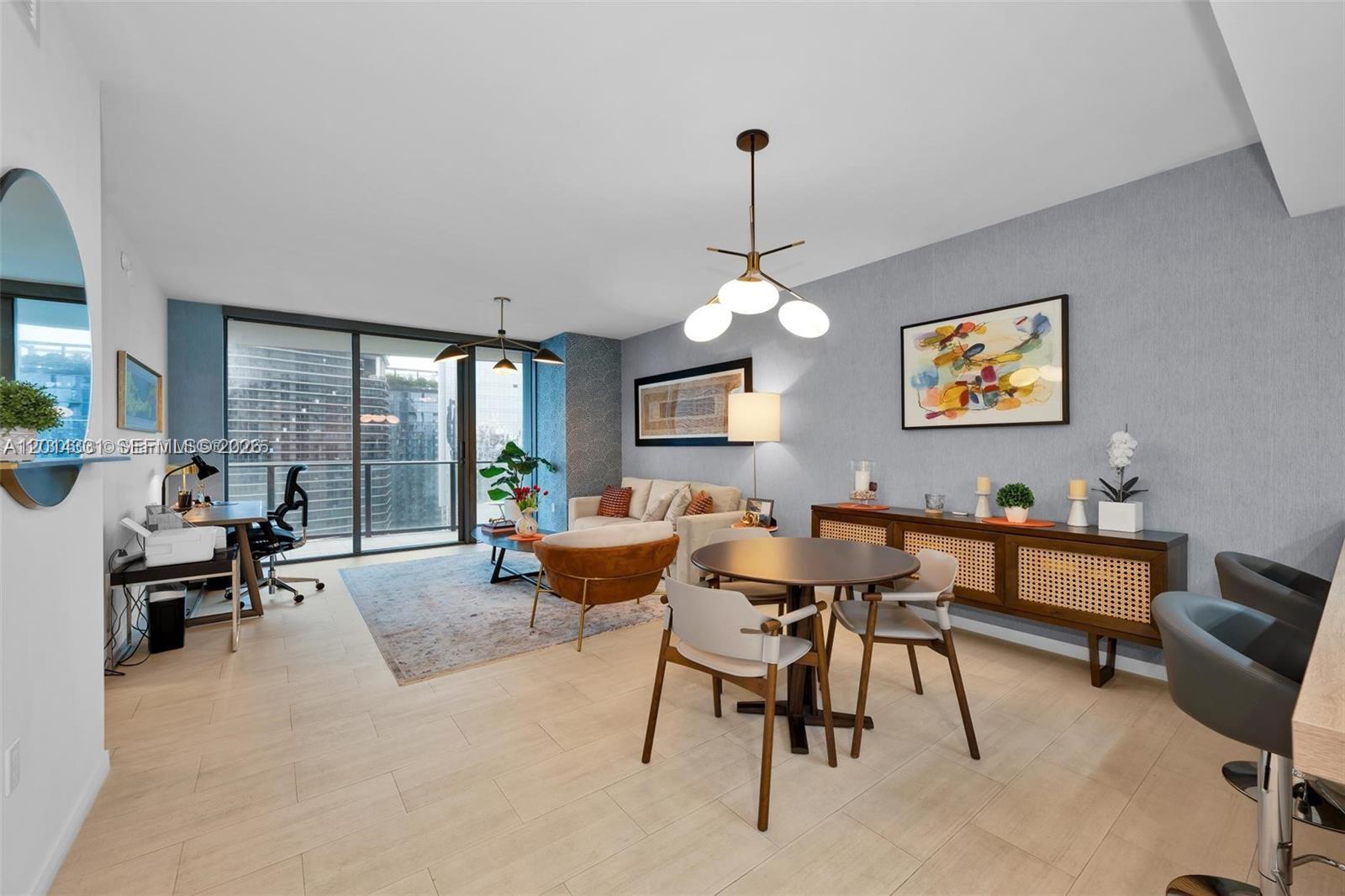 A modern living and dining area features light wood floors, blue walls, and balcony views — 1000 Brickell Plz # 3914, Miami FL 33131, MIAMI, FL