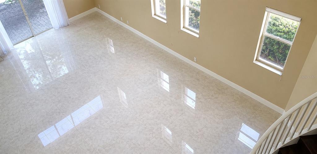 An elevated view of a living room with light-colored tile flooring and white trim — 143 NW 117TH AVENUE, PLANTATION, FL