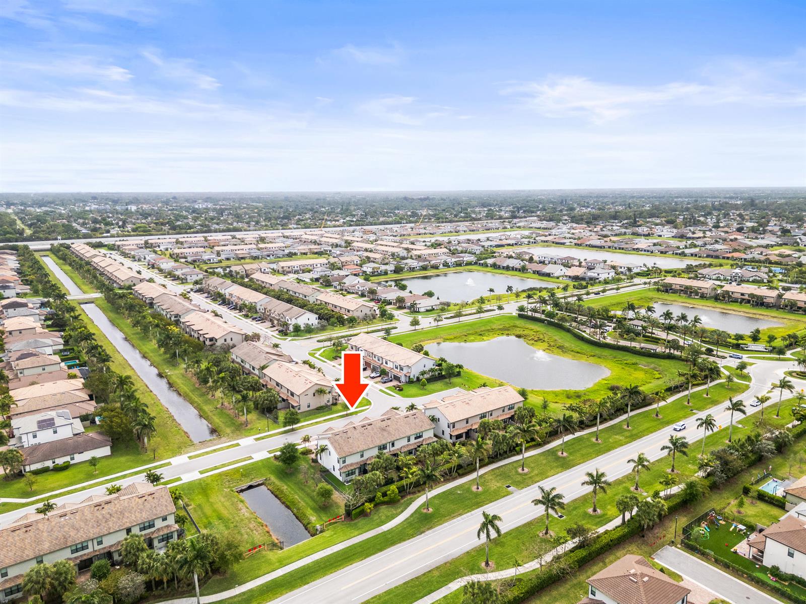 An aerial view shows a residential neighborhood with townhomes, ponds, and landscaped green spaces — 4739 Eventing Street, Lake Worth FL 33467, LAKE WORTH, FL