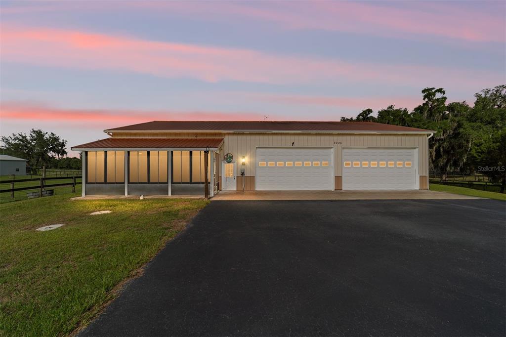 A single-story building with a screened porch and two garage doors sits on a lawn — 2035 NW 150TH AVENUE, OCALA, FL