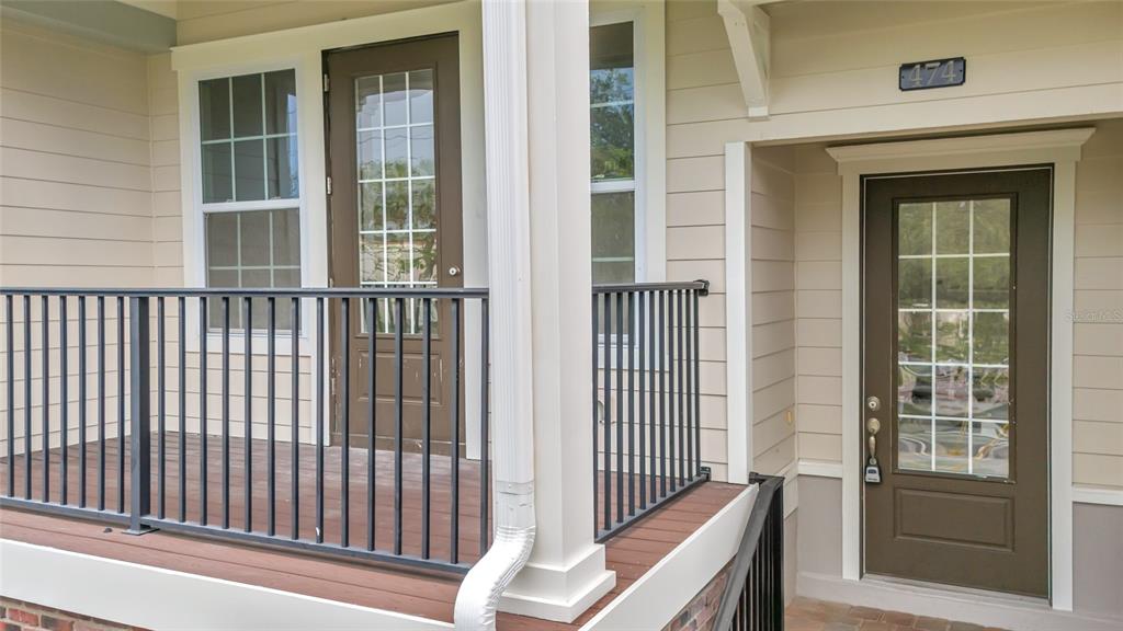 A porch with a black metal railing leads to two brown glass-paneled doors — 474 WINDMILL PALM CIRCLE, ALTAMONTE SPRINGS, FL