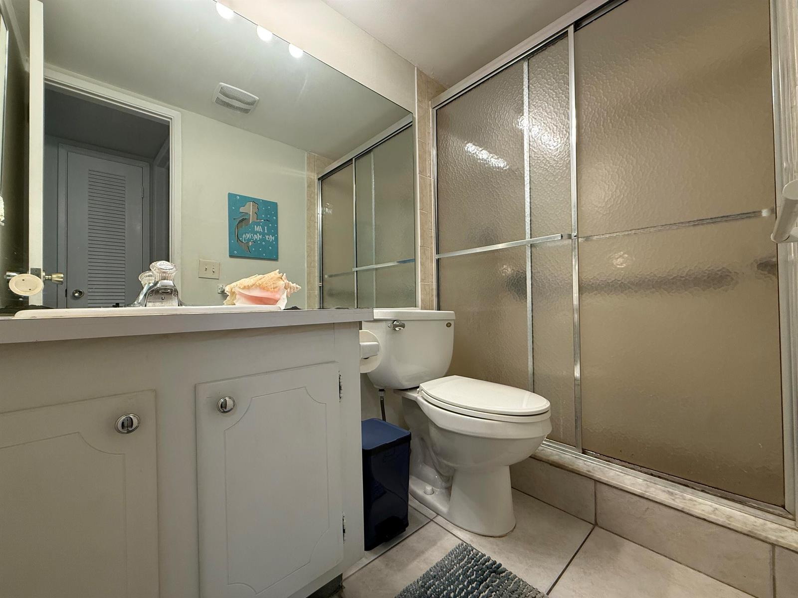 A bathroom features a white vanity, a toilet, and a glass-enclosed shower with tiled floors — 1040 SE 4th Avenue # 331, Deerfield Beach FL 33441, DEERFIELD BEACH, FL