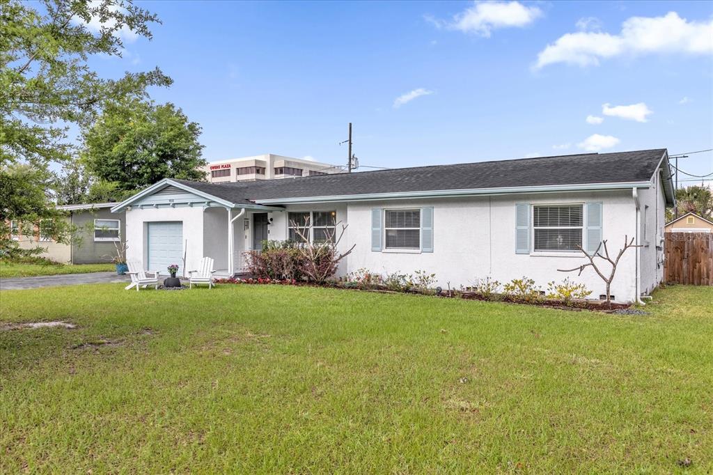 A single-story white house with a garage and a front lawn under a blue sky — 950 HANOVER AVENUE, WINTER PARK, FL