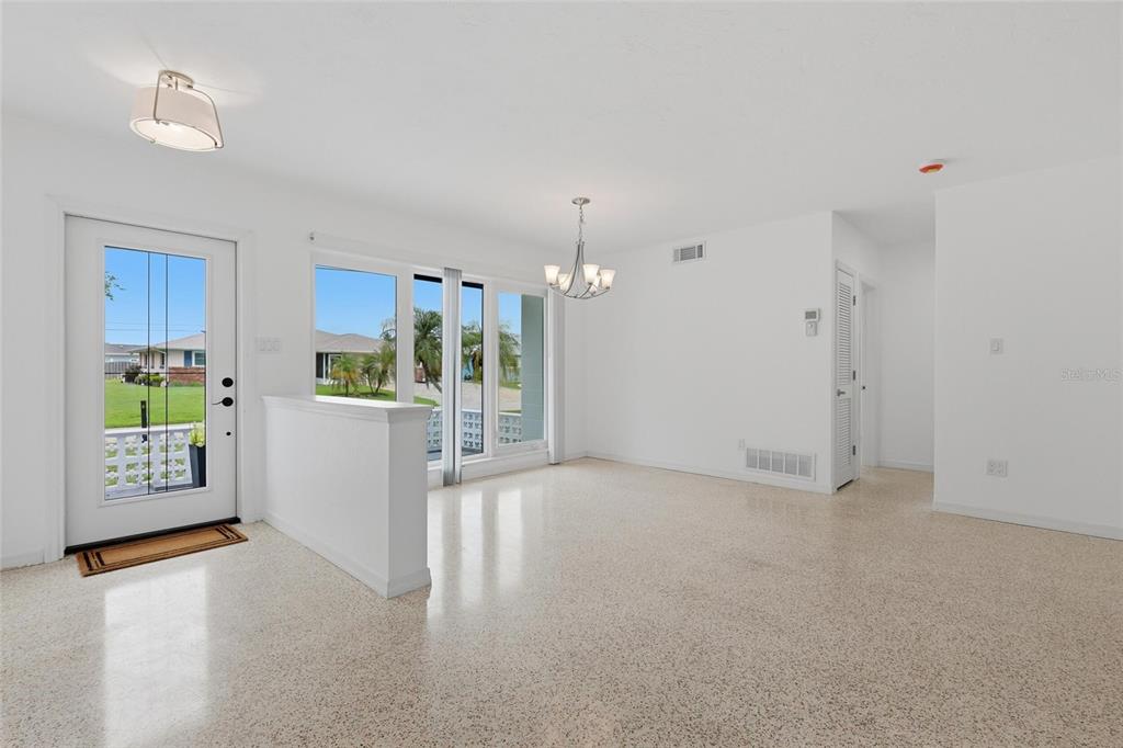 An open dining area features white walls, a chandelier, and light-colored speckled flooring — 412 W SHADE DRIVE, VENICE, FL