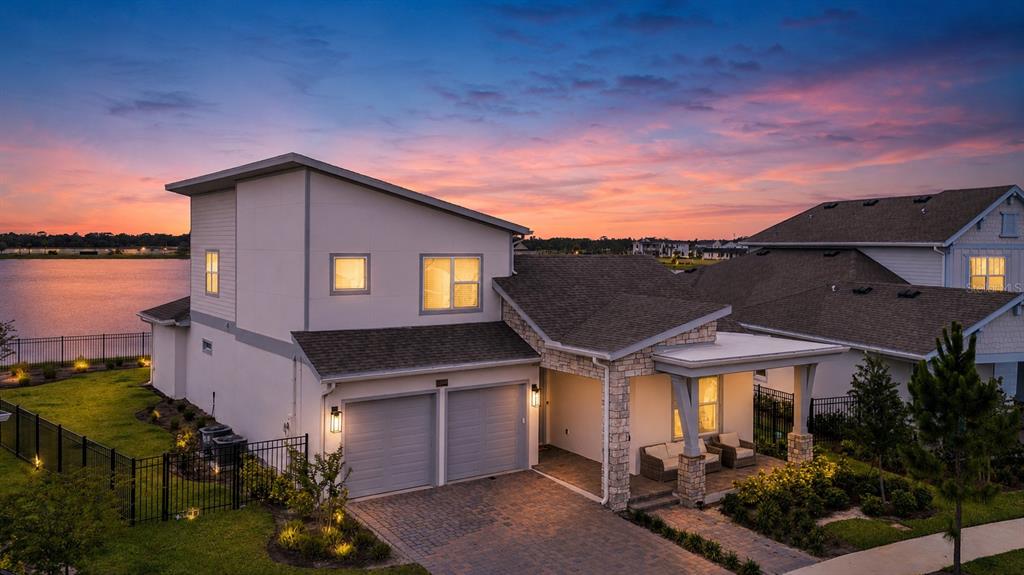 An exterior view of a two-story house with a garage and a covered front porch — 10044 BALLAST DRIVE, ORLANDO, FL