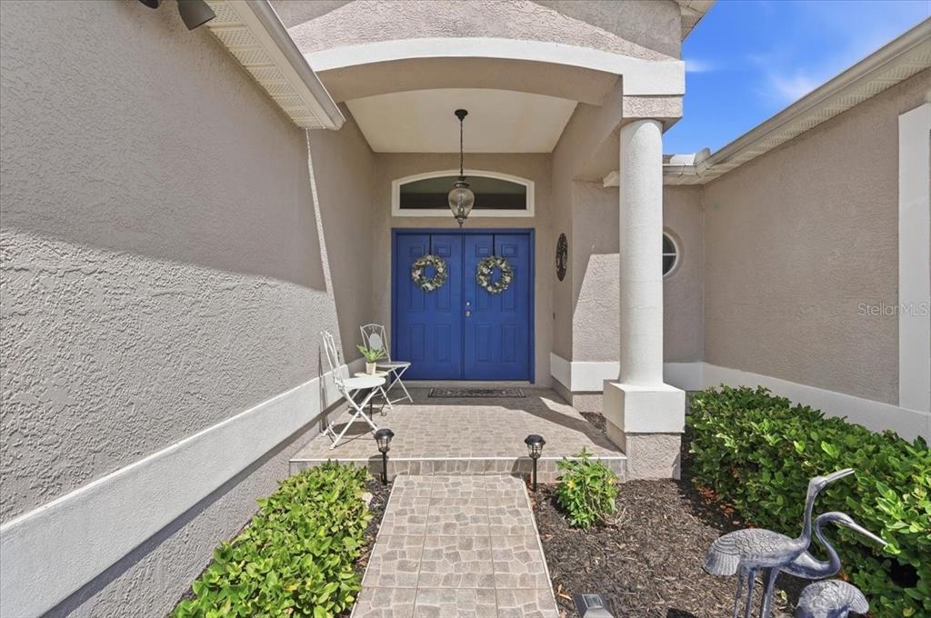 A front entryway features a blue double door, a stone walkway, and a covered porch — 5832 SWALLOW DRIVE, LAKELAND, FL