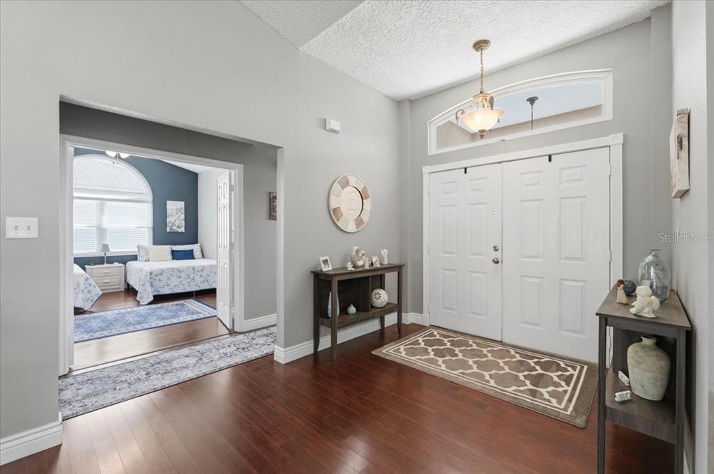 A bright entryway features dark wood floors, a double front door, and a bedroom view — 5832 SWALLOW DRIVE, LAKELAND, FL