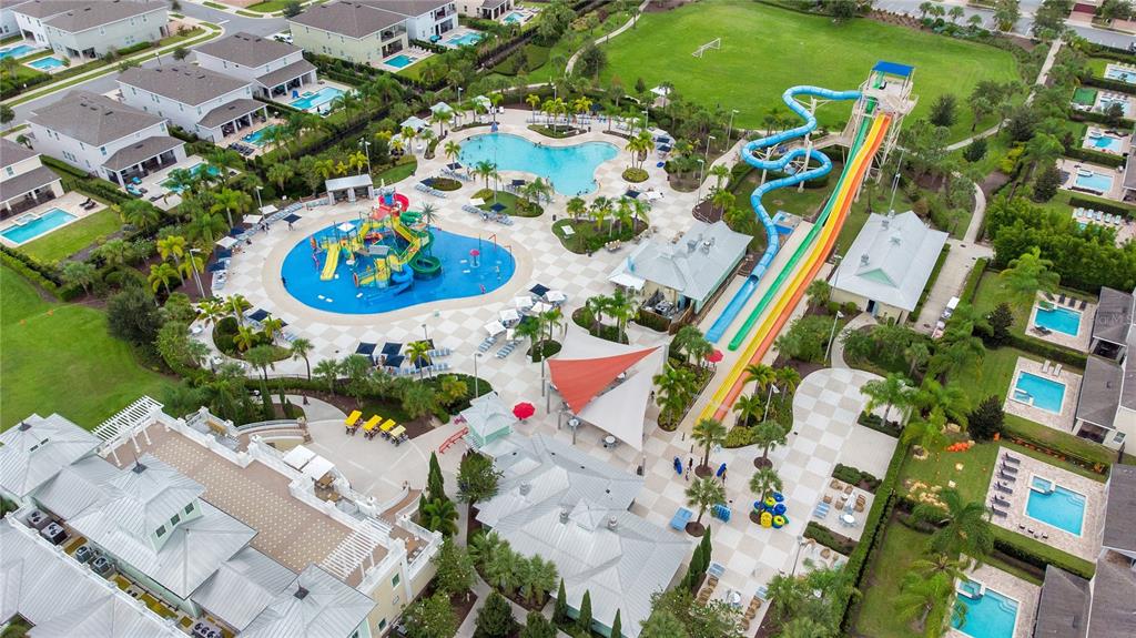 An aerial view shows a community pool complex with water slides, a splash pad, and surrounding houses — 410 NOVI PATH, KISSIMMEE, FL